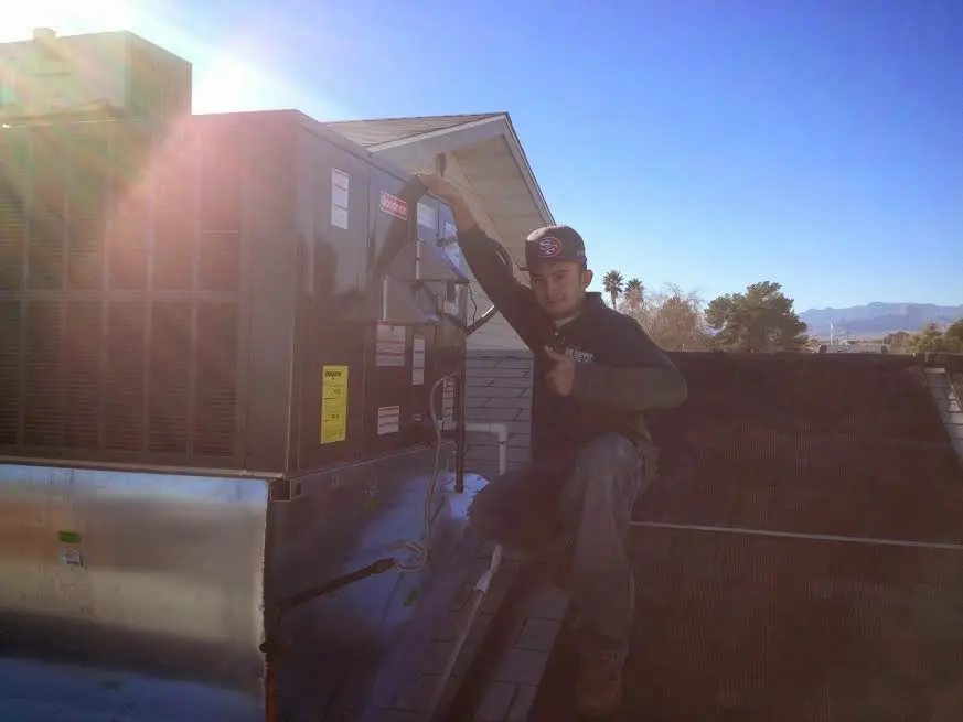 HVAC technician performing HVAC Inspection on a rooftop unit in Naugatuck